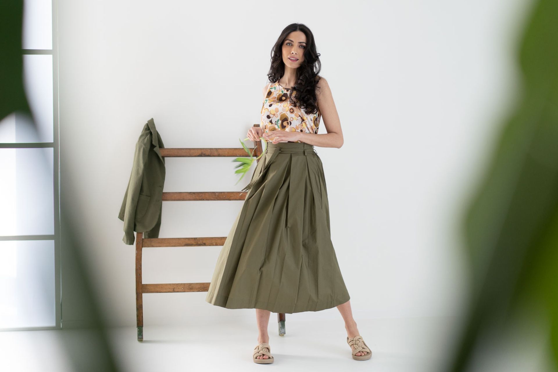 Donna in piedi che indossa gonna verde militare ampia con blusa abbinata